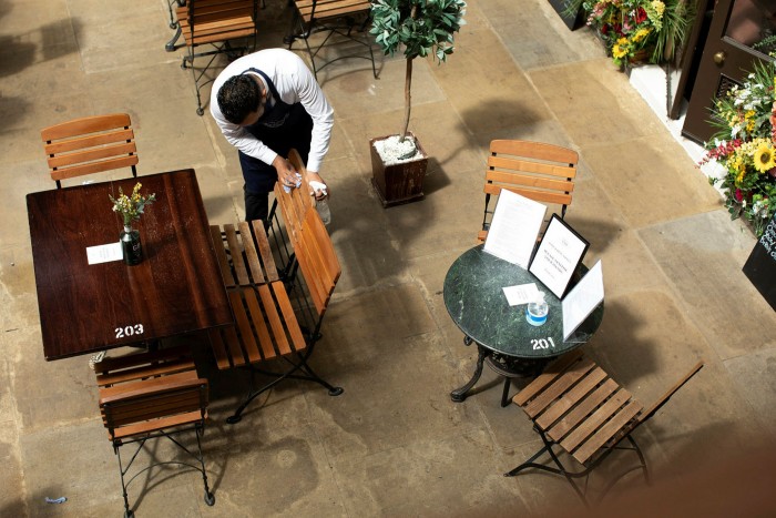 top shot of restaurant tables being cleaned by male staff
