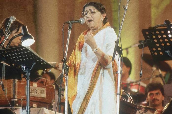 Lata Mangeshkar performs in Mumbai in 1997. On summer evenings, people would sit outside their homes listening on radios as her voice floated above the city's 'chawls'