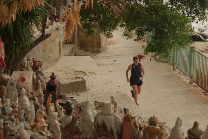 Christy Barlow runs past statues of gods and Buddhas in Waterfall Bay Park