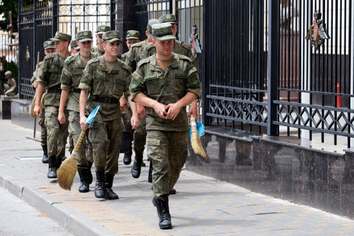 Russian soldiers are posted to clean the area around the city’s military headquarters 