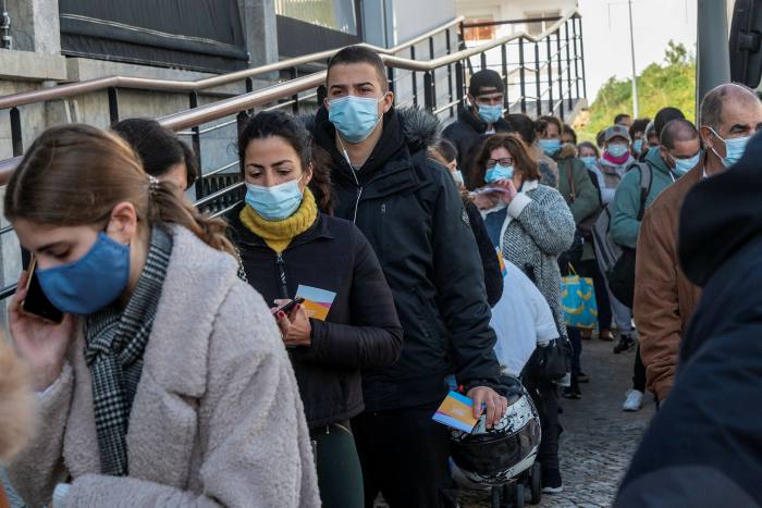 People queueing for antigen tests in Portugal: whether new pathogens generally tend to become milder over time as they become established in human populations is a matter of debate among scientists