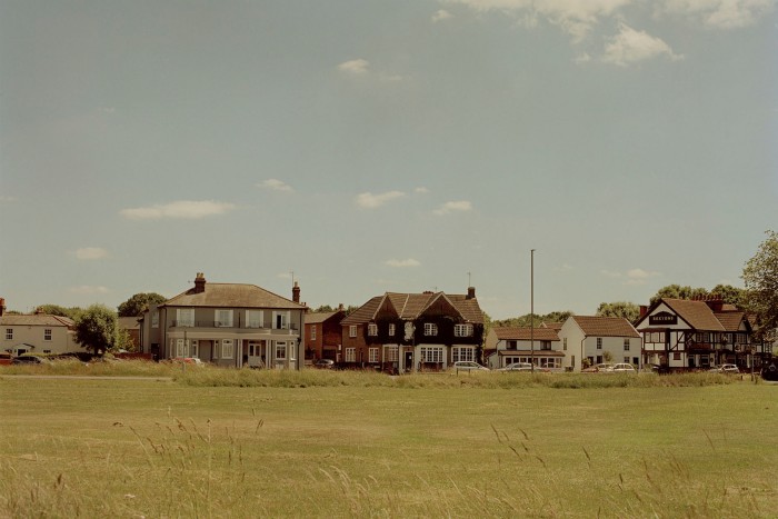 A view of houses across a field on sunny day