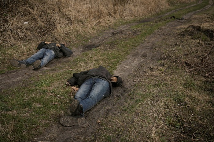 Los cuerpos de dos hombres yacen en un camino de tierra en Bucha.
