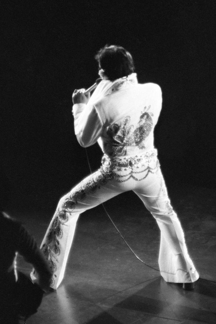 Elvis seen from behind wearing a rhinestone-studded suit