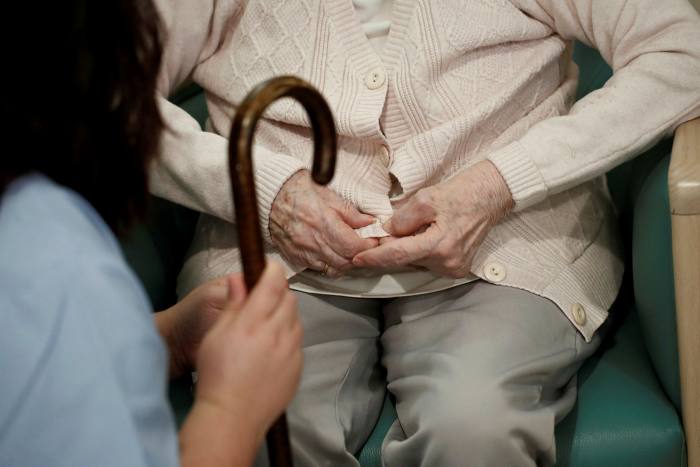 A medical worker with an elderly resident at care home in France. Research in the country suggests staff were the source of a third of the coronavirus clusters found in such settings