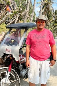 Dale, a Batan resident, next to his tricycle