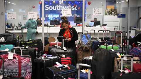 A Southwest Airlines ground handler sorts through unclaimed luggage at LAX last year