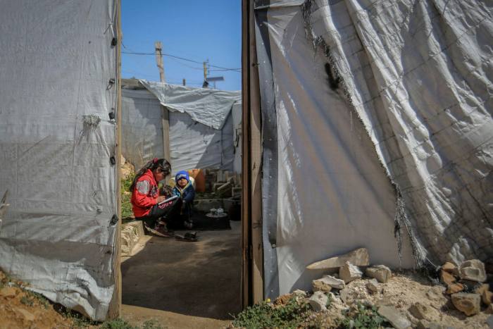 Syrian siblings outside their tent at a refugee camp in the Lebanese town of Aarsal