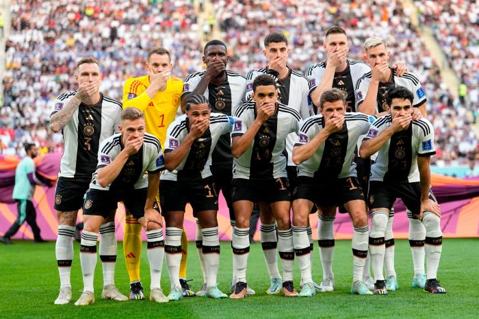 Germany football players covering their mouths on the pitch