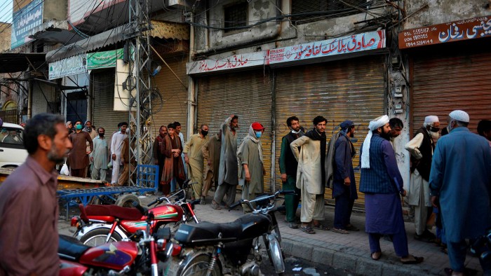 Pakistani labourers queue for free food during a government-imposed coronavirus lockdown this year