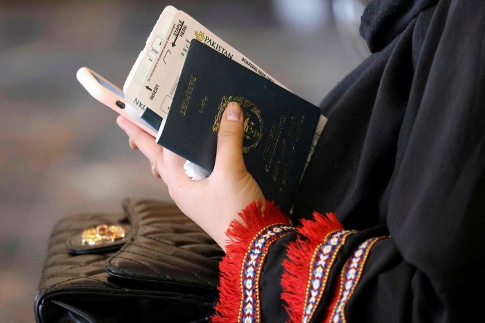 A traveller holds their passport as they prepare to board a flight from Kabul on September 13