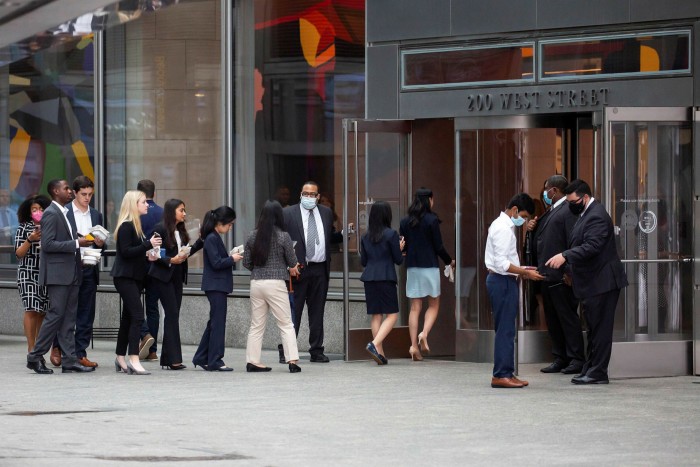 People wait in line to enter outside the Goldman Sachs headquarters building in New York