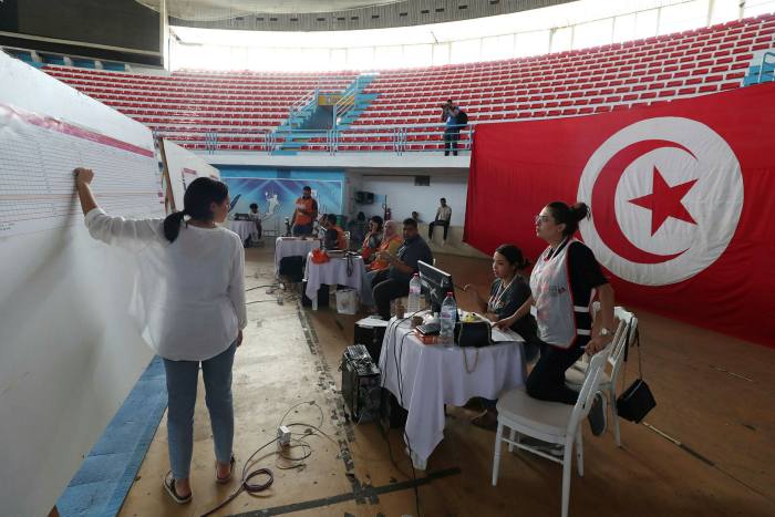 Tunisian electoral officials work at a vote counting center following the referendum