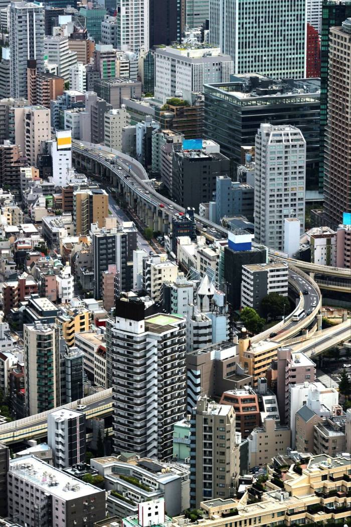 An aerial view of tall buildings and freeways in urban Tokyo