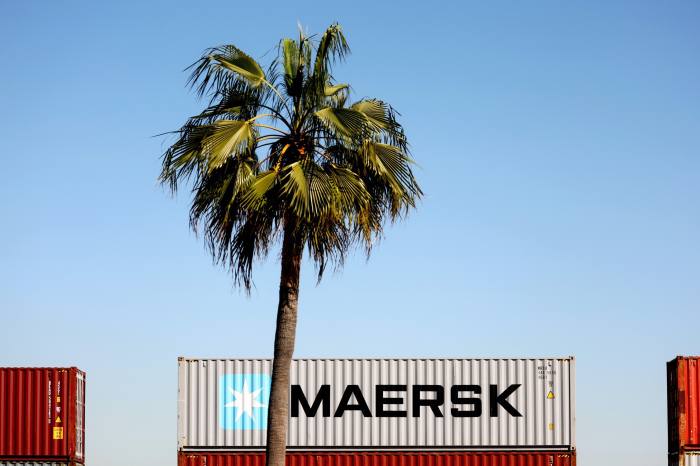 A Maersk shipping container sits on a rail car