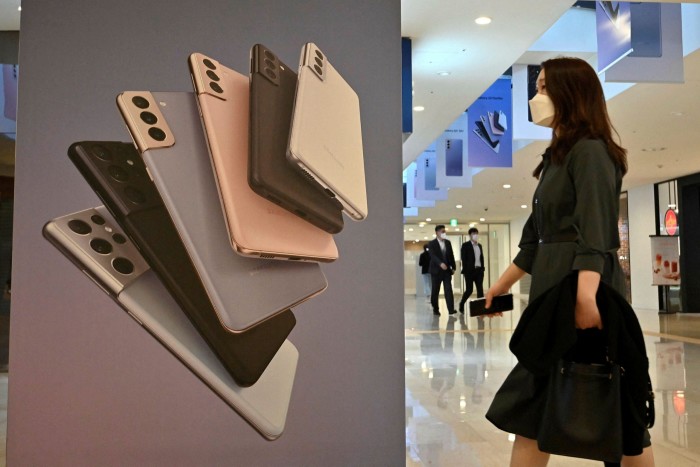A woman walks past an advertisement for the Samsung Galaxy S21 smartphone at the company’s showroom in Seoul