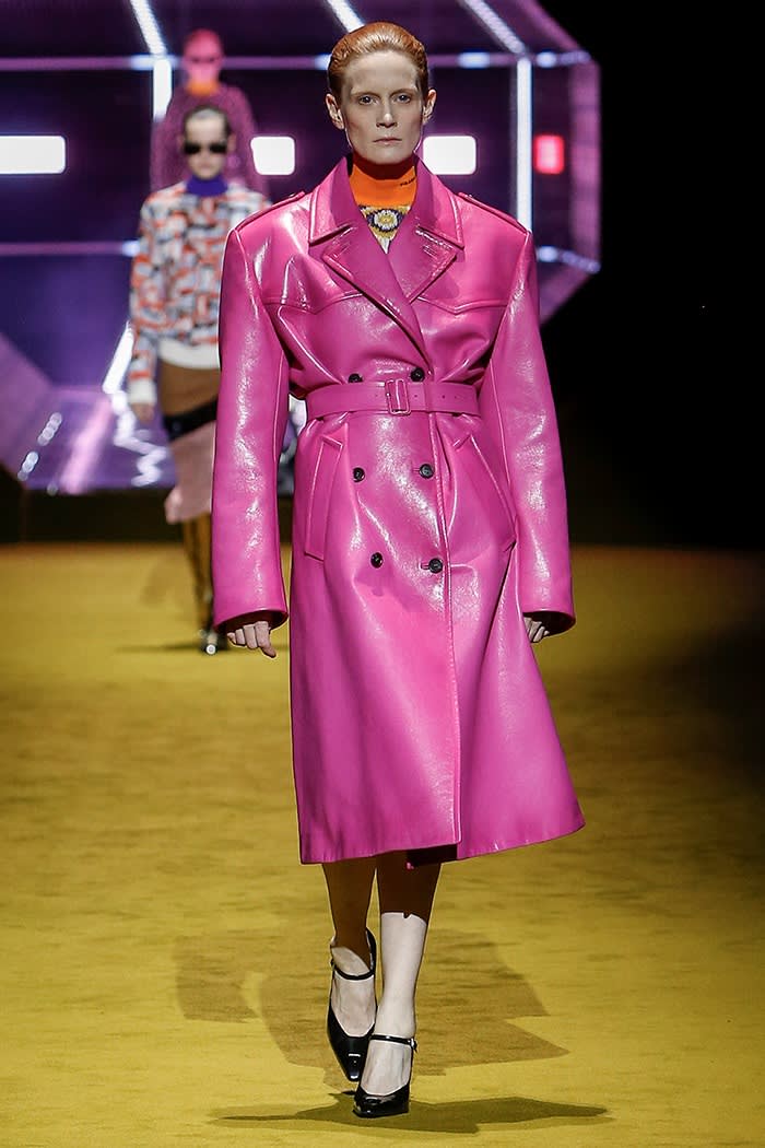 A catwalk model wears a trench coat in bold bubblegum pink