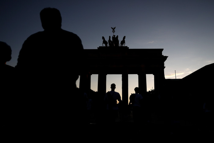 Visitors at a dark Brandenburg Gate in Berlin
