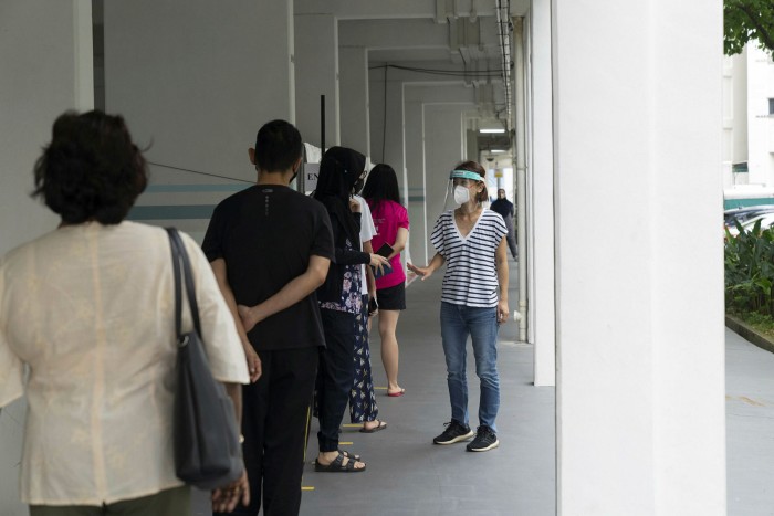 Residents of a Singapore housing block queue for mandatory testing on Saturday