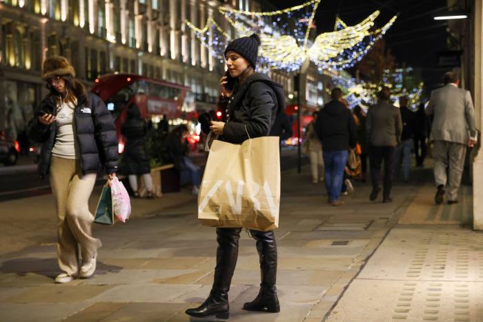 Een klant draagt ​​een tas van Zara in Regent Street, Londen