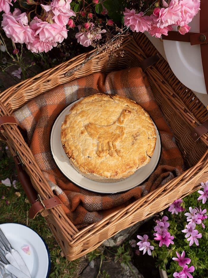 Chicken and ham pie with broad beans on a serving plate