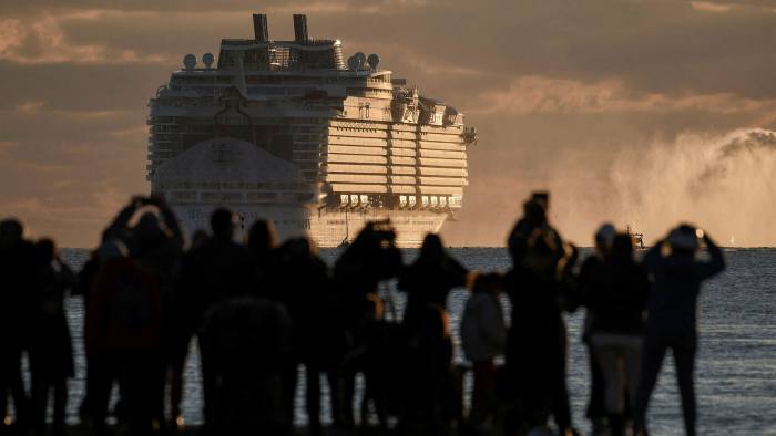 People watch the departure of a cruise ship