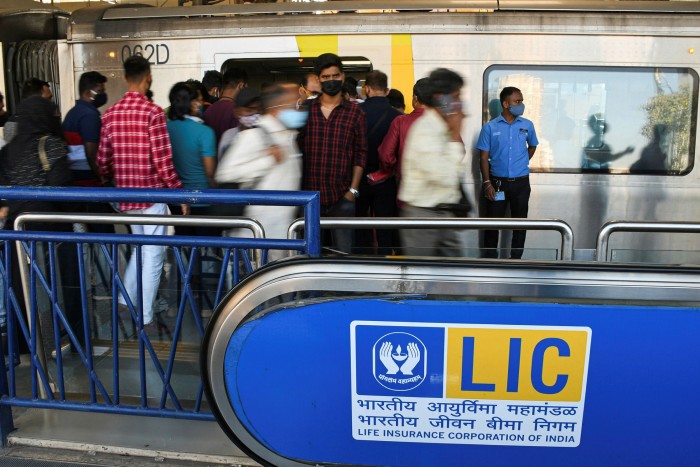 LIC branding at metro station in Mumbai and people boarding the train 