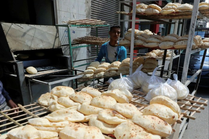 A  baker arranges bread at a bakery 
