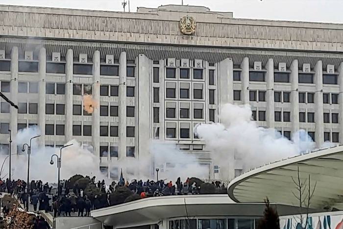 Smoke rises as protesters gather near the Almaty city hall during the most violent protests in Kazakhstan's history.
