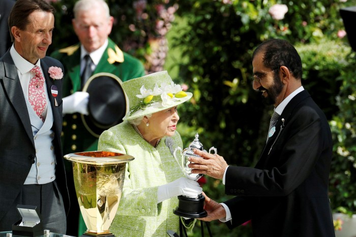 Queen Elizabeth presents Dubai’s ruler Sheikh Mohammed bin Rashid al-Maktoum with a trophy as the winning owner of the Diamond Jubilee Stakes at Ascot in June 2019