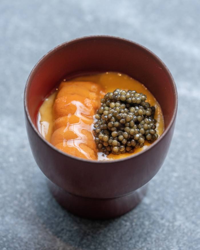 A small red dish containing uni from Hokkaido with Kaluga caviar, on top of soft scrambled egg, potato foam and sushi rice