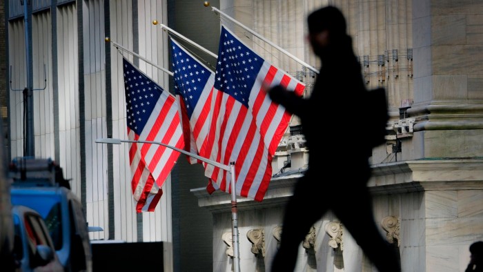 A pedestrian walks past the New York Stock Exchange