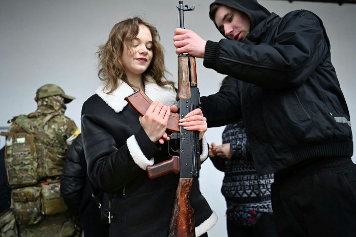 A woman holding an AK-47 