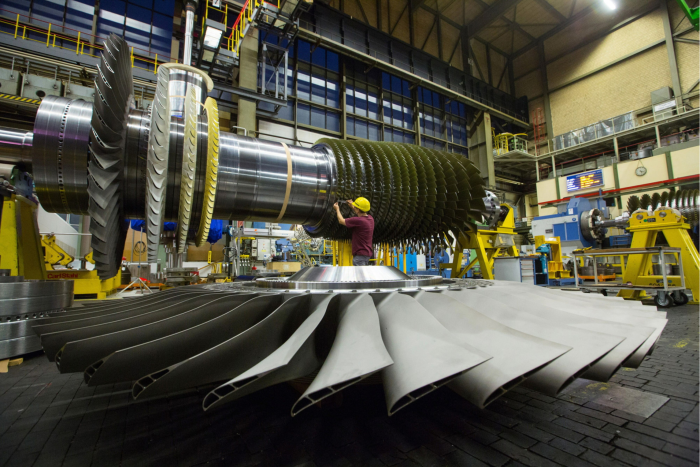 An employee takes blade measurements on a F-class turbine on the assembly line of Siemens AG’s gas turbine factory
