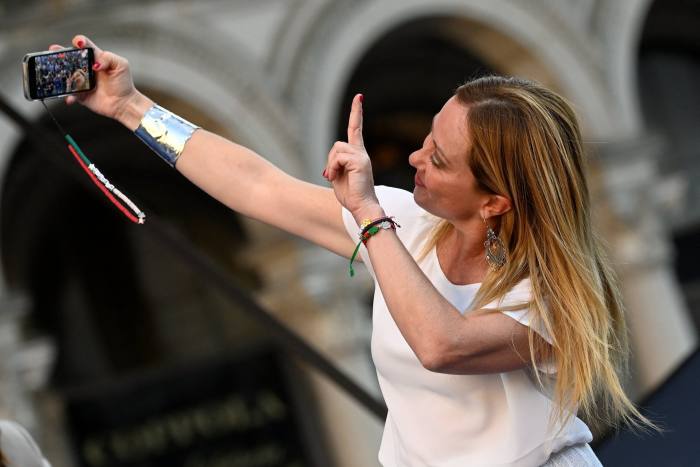 Giorgia Meloni, leader of the far-right Brothers of Italy party, takes a selfie during a rally in Duomo square, Milan