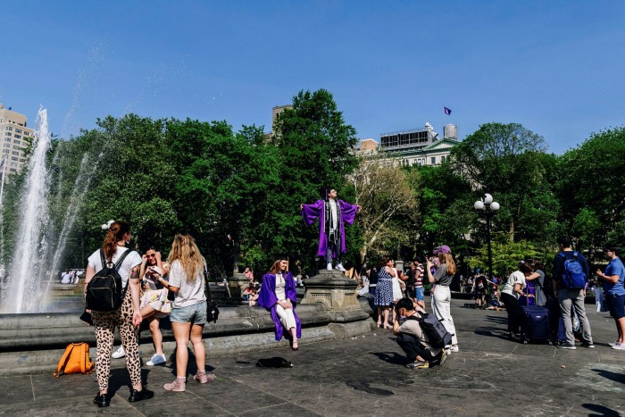 Graduating students take photographs in New York. Analysis shows that at 35, baby boomers held 21% of US wealth, compared with 8% among Generation X and 5% for millennials