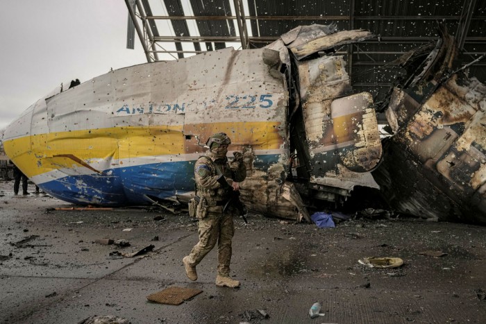 A Ukrainian serviceman walks past a destroyed aircraft at Antonov airport in Hostomel, Ukraine
