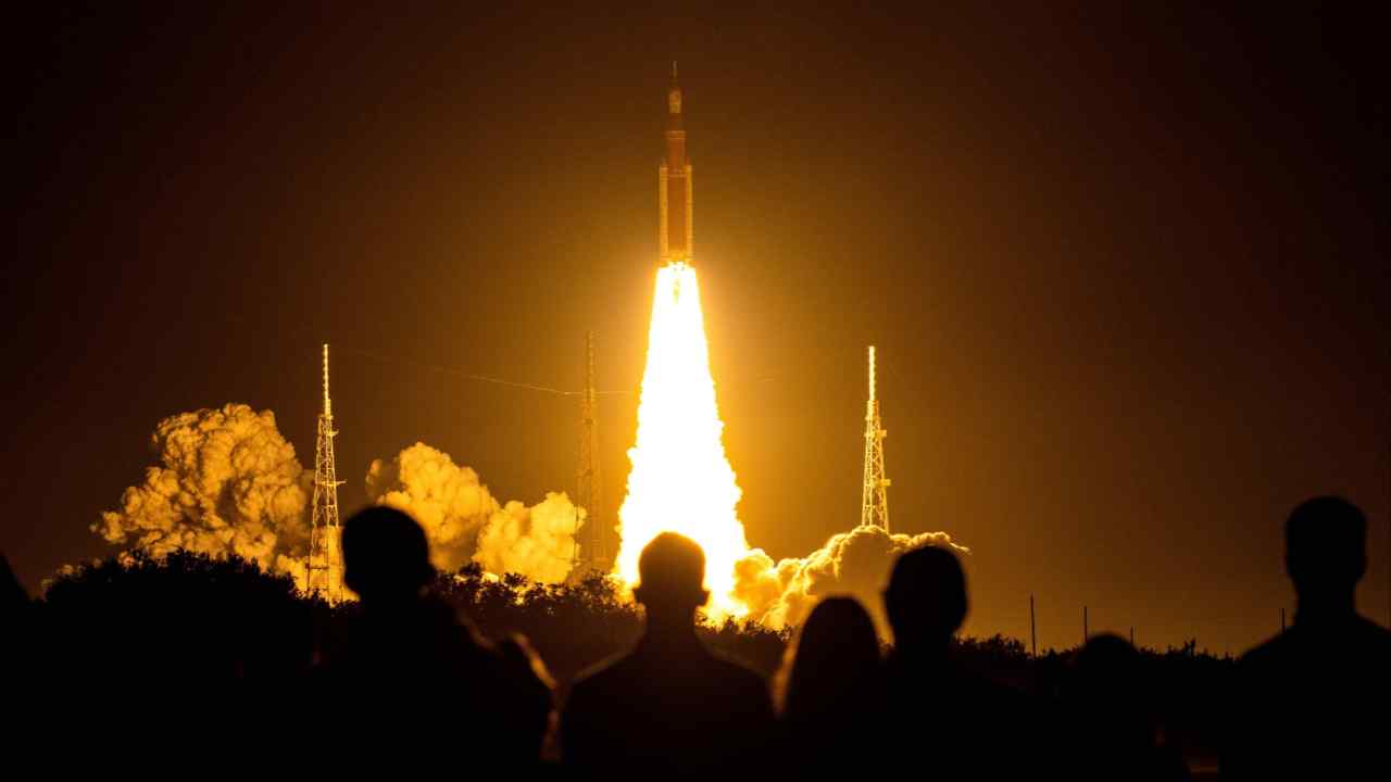 Spectators watch as the Artemis I unmanned lunar rocket lifts off from Cape Canaveral, Florida