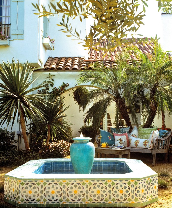 The exterior of a Spanish colonial house with lush garden