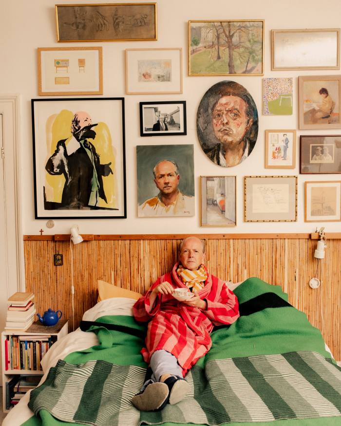 Adrian Dannatt in his bedroom, with portraits of him by Sacha Floch Poliakoff (bottom row, far left), Paul Benney (bottom row, second from left), Orlando Mostyn Owen (oval painting in the centre) and Joan Dannatt when he was a child (middle row, far right)