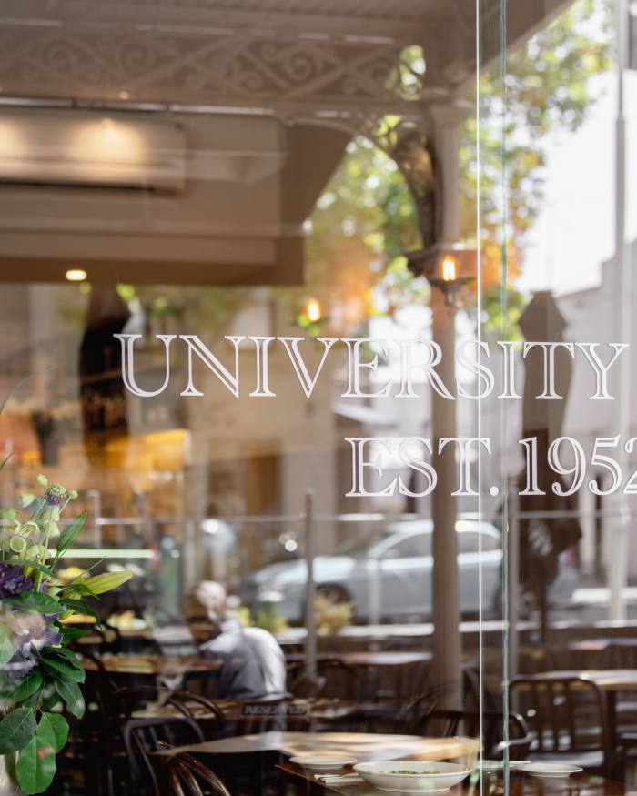 A close-up of University Café’s front window, on which its name is engraved