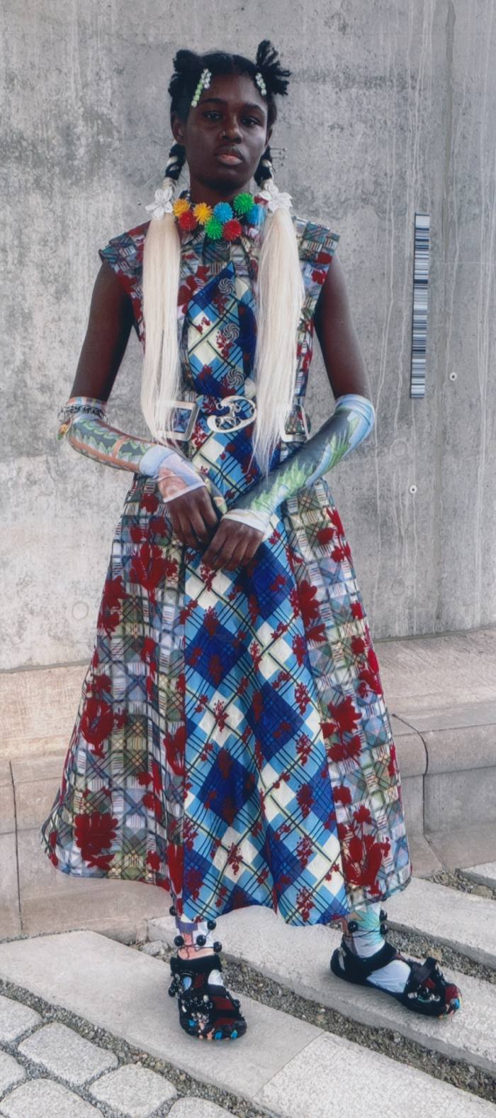 A model wears a colourful midi, with fingerless gloves and a stole