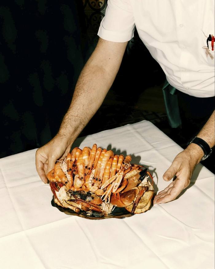 Một đĩa hải sản do một nhân viên của Ribeira do Miño cầm