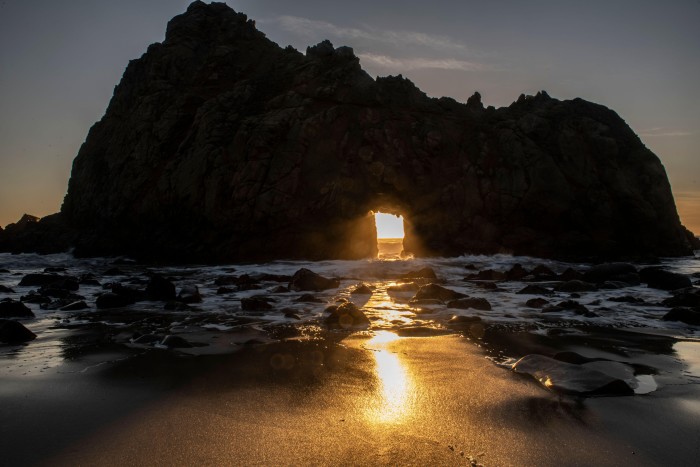 The sunset through Keyhole Rock on Pfeiffer Beach in California