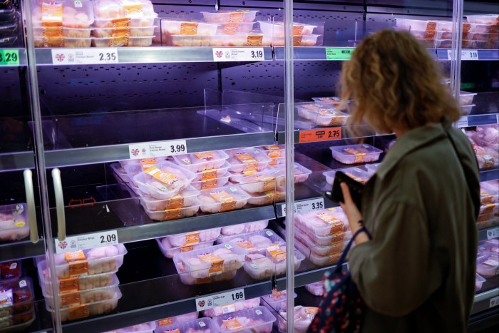 A woman shops for chicken at a Lidl supermarket in London. The UK grocery sector has been locked into a race to the bottom on prices since the arrival of German discounters Aldi and Lidl