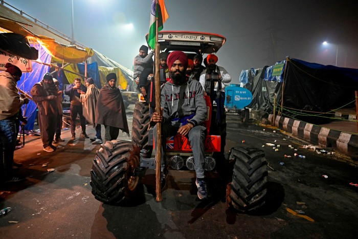 Farmers sit on a tractor along a blocked highway as they protest 