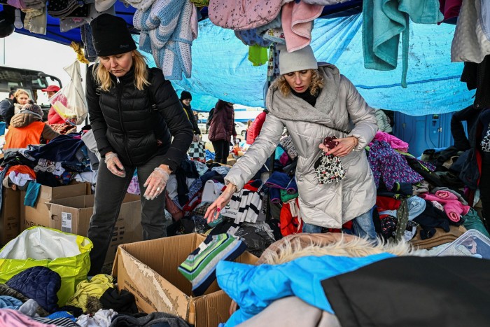 Refugees who managed to get to Przemysl, Poland, pick clothes and food donations at a supermarket car park