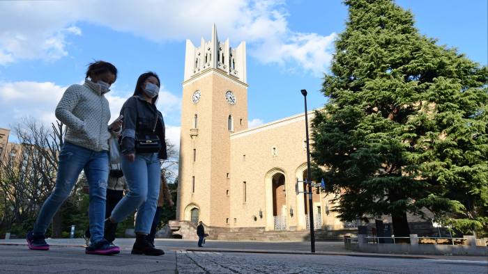 Students wearing face masks walk on the campus of Waseda University in Tokyo