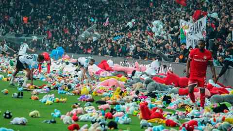 Beşiktaş fans throw colourful stuffed bears on to the pitch