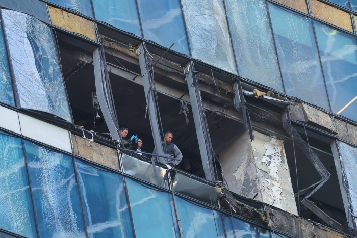 Members of Russia’s security services examine a damaged office building in the Moscow City business district following a drone attack 